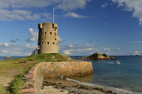 Le Hocq, Jersey, U.K. Wide angle image of an uninhabited 19th century tower from the Napoleonic Wars on a Summer evening at high tide.
