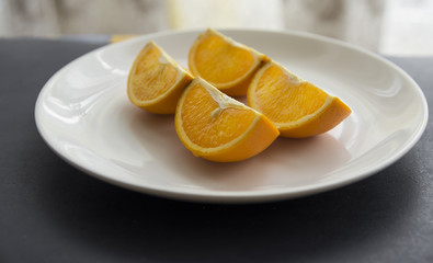 Fototapeta na wymiar Orange cut in to slices on the white plate