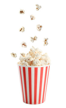 Cup and tasty popcorn on white background