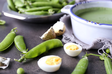Sliced quail egg and green pea pods with casserole of puree on table