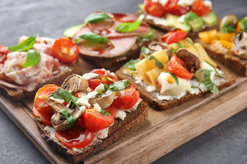 Composition with tasty homemade sandwiches on wooden board