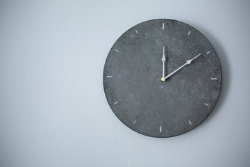 Big clock hanging on grey wall