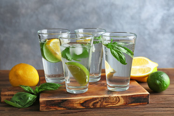 Board with glasses of basil water on table