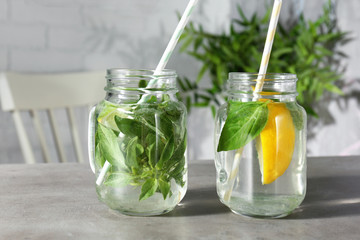 Jars with basil water on table