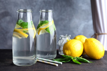 Bottles with basil water on table