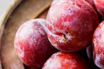 Ripe Organic Big Red Plums on Vintage Metal Plate. Top View. Vibrant Color. Copy Space. Autumn Harvest Thanksgiving Healthy Food.