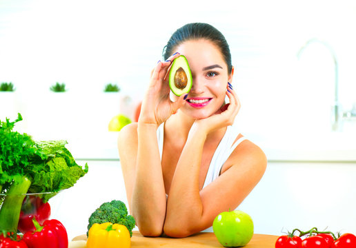 Beauty young joyful woman holding fresh avocado. Healthy eating concept