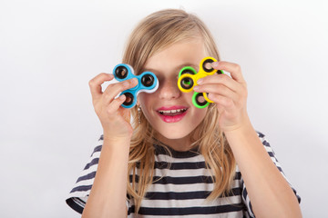 Funny girl playing with four fidget spinners