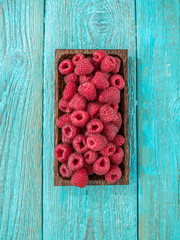 Fresh raspberry in a wooden plate