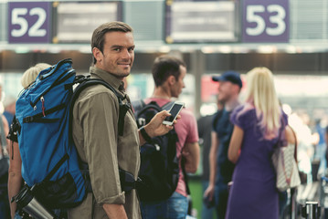 Pleasant guy is waiting for registration at modern airport