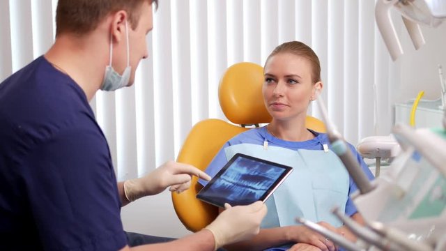 Patient is in the dental chair and listens to the explanations for x-ray image