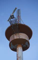 Bottom view of meteorological tower station over blue sky background