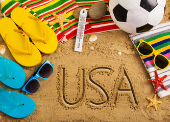 Summer concept of sandy beach, colorful flip flop shoes, sunglasses, ball and inscription