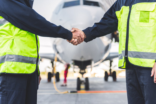 Mechanics joining hands at airport