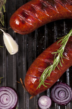 Close up of grilled sausages in a pan on wooden background