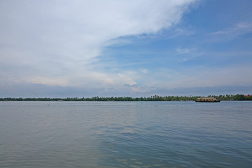 Houseboat on serene and still water on a sunny day on the Kerala backwaters, India