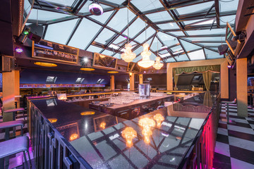 Empty bar counter with reflection of chandeliers and skylight