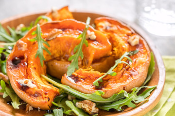 Roasted pumpkin with pecan nuts and arugula.