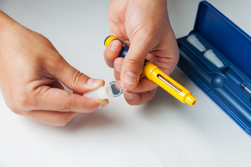A man holds a syringe for subcutaneous injection of hormonal drugs in the IVF protocol (in vitro fertilization). Medical product in ampoules. Preparation for pregnancy. Helping Wife