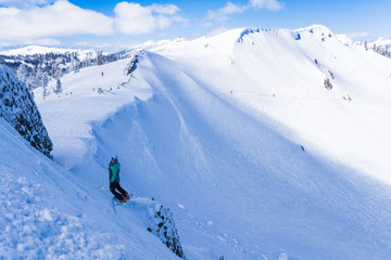 Mixed race woman on snowboard balances on a cliff and smiles