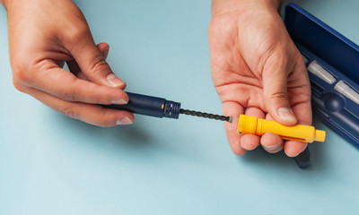 A man holds a syringe for subcutaneous injection of hormonal drugs in the IVF protocol (in vitro...