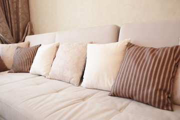 Fototapeta na wymiar Cozy light sofa with pillows in living room