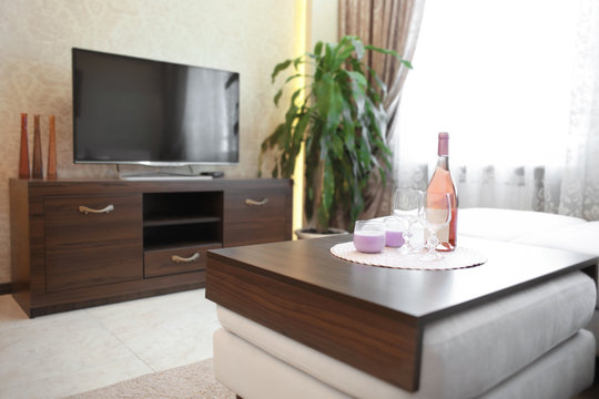 Table with glasses and bottle of champagne in modern living room