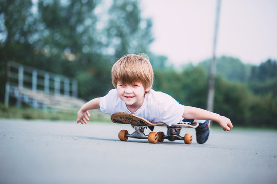 Happy little boy on skateboard outdoor. - Powered by Adobe
