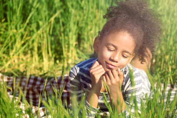 Little Afro American girl in green field