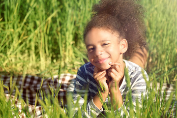 Little Afro American girl in green field