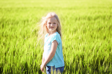 Happy little girl in green field