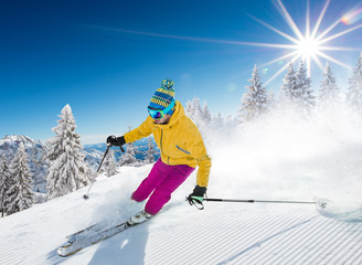 Skier skiing downhill in high mountains