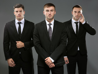 Handsome bodyguards on grey background