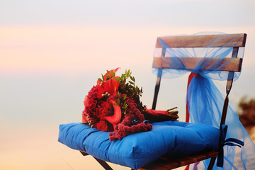 Wedding decoration. Bridal bouquet placed at the chair with blue cushion.