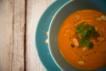 Squash soup served with parsley and pumpkin seeds / Autumn concept