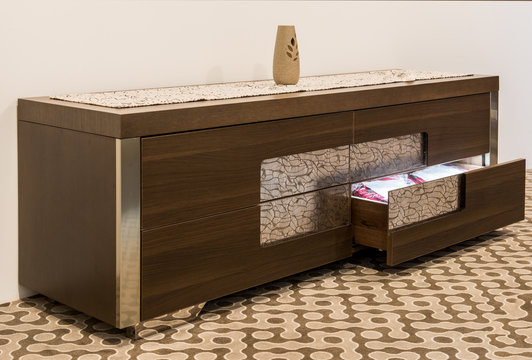 Wooden chast with open drawer in home interior