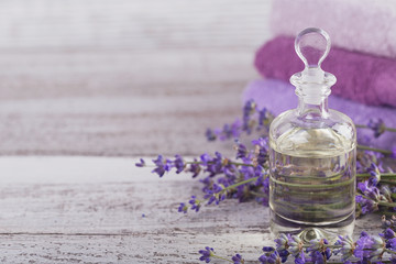 Bottle of essential oil and fresh lavender flowers