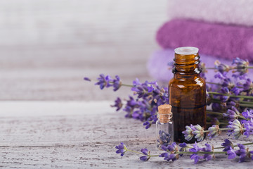 Bottle of essential oil and fresh lavender flowers