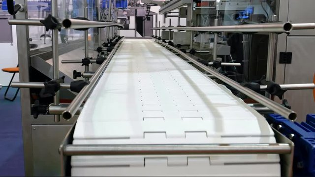 Food factory automated robotic machine. Conveyor product line for cooking and packing rations and food packs. Robotics and automatic lines used instead of human labor on factories and plants.