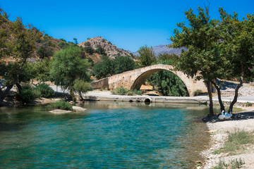 Panorama of kourtaliotis river and a stone arch bridge at Preveli, Crete, Greece