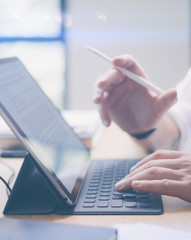 Blogger working at studio.Closeup view of male hands typing on electronic tablet keyboard-dock...