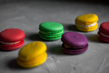 Obraz na płótnie Canvas Sweet and colorful french macaroons or macaron on gray background, Dessert.