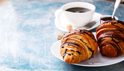   Breakfast Continental  with Fresh  Croissants on a blue Background Coffee  and milk Delicious Baking with  with Chocolate Topping   Copy space for Text