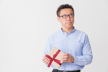 プレゼントを持つミドル男性　考える