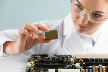 Woman engineer looking at a circuit board.