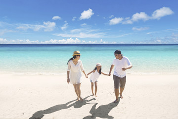 Young parents with daughter on the beach