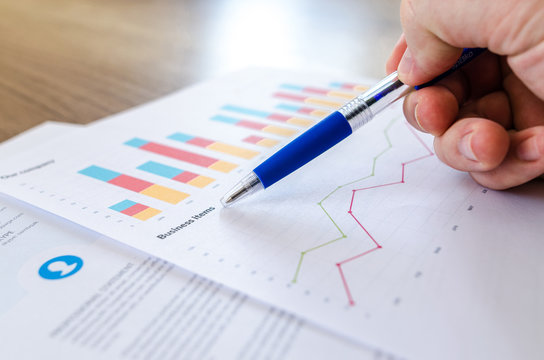 Man showing business graph on wood table