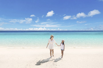 Fototapeta na wymiar Mother and child walking on the beach