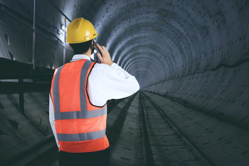 Engineer with mobile phone in the tunnel