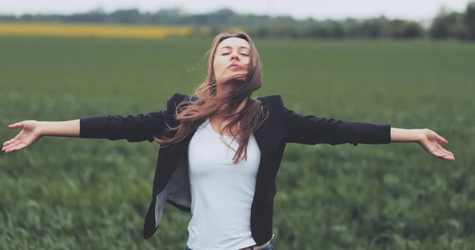 Portrait of Business Woman Standing on the Wind with Hands Up. SLOW MOTION 4K DCi. Businesswoman enjoying the wind, feeling free. Stormy weather, autumn, winter, spring. 